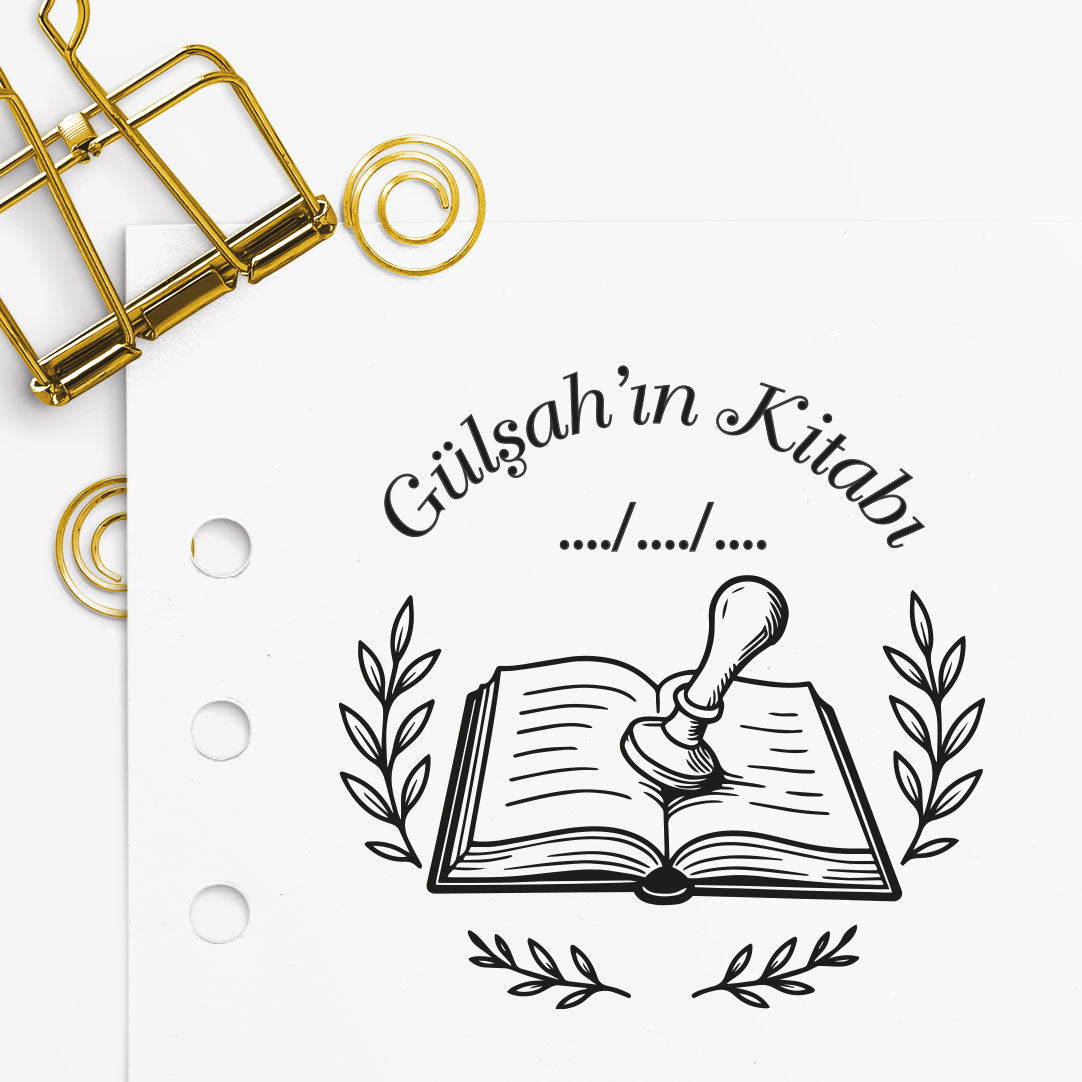 Açık kitap üzerine mühür basan el figürlü kitap mührü tasarımı, 'Gülşah'ın Kitabı' isim örneği ve zeytin dalı detaylarıyla